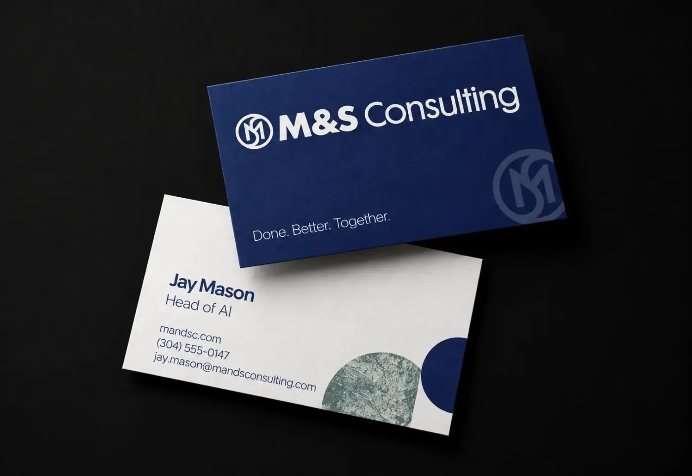 Two M&S Consulting business cards: a navy face carrying the lockup and Done. Better. Together., and a cream reverse with contact details and the brand's geometric shapes